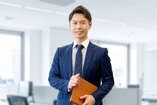 オフィスでほほえむスーツ姿の男性