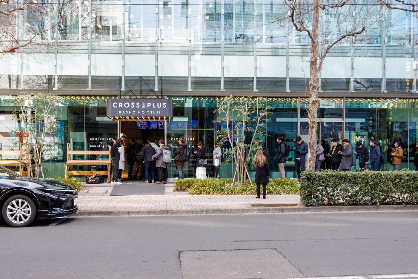 会場となるCROSS B PLUSの外観。ガラス張りの建物にCROSS B PLUSの看板が掛かり、入口前に来場者が並んでいる。